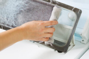 person pulling lint off lint trap